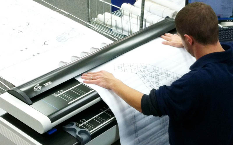 A picture showing a person scanning a drawing
