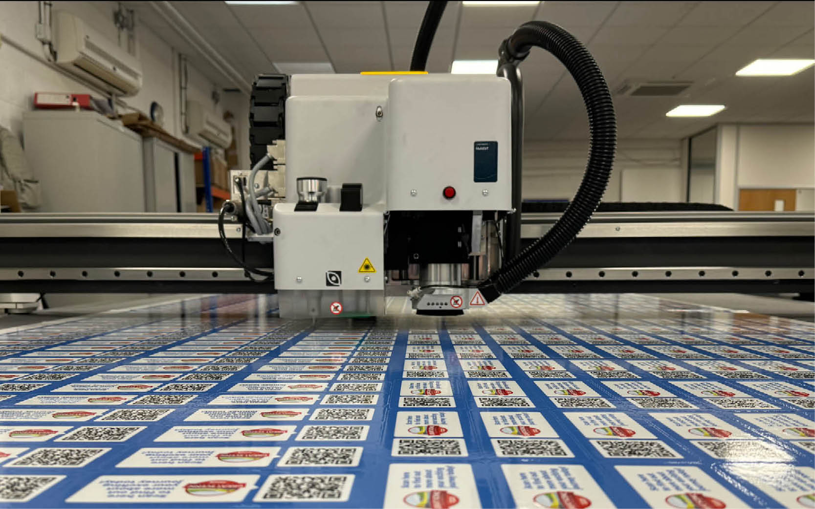 A picture showing a Kongsberg cutting table cutting stickers