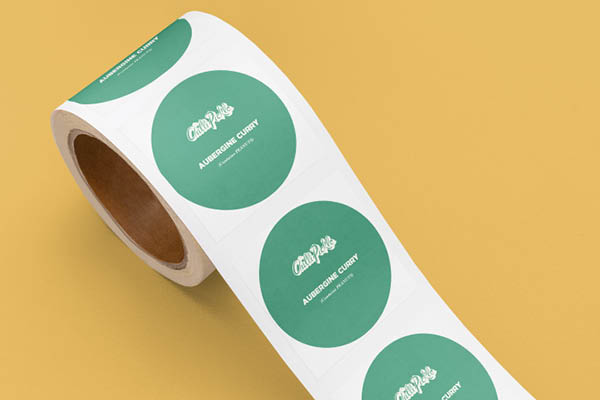 A roll of green circular labels with white text, displayed against a yellow background.